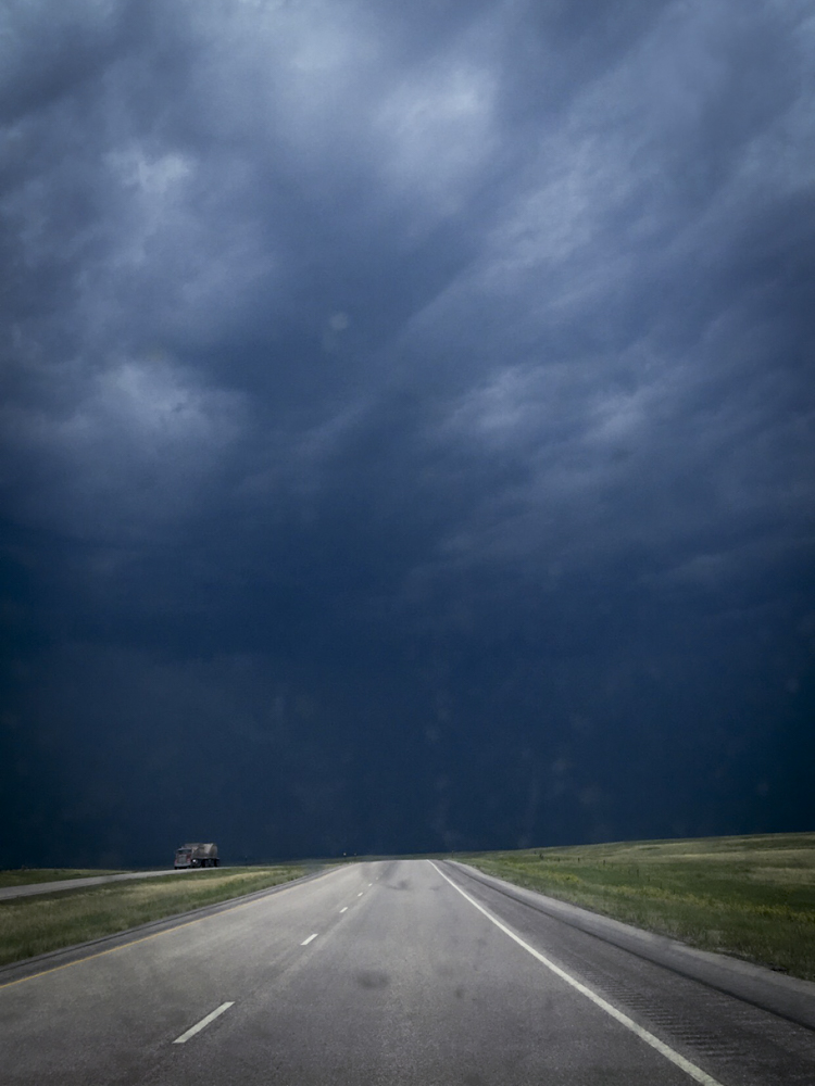 Open road and a foreboding stormy blue sky