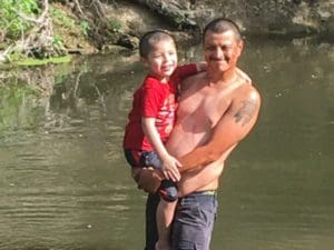 Father son at play in the water with smiles